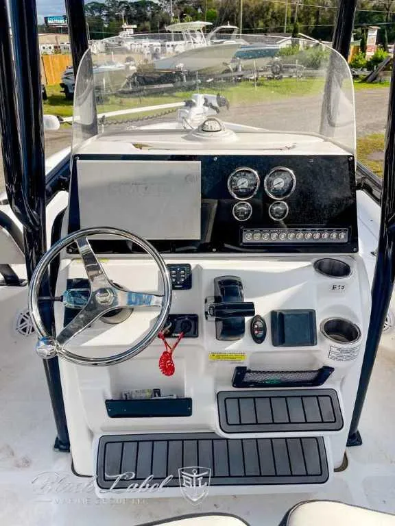 Slide: The Image of 2022 Tidewater 2210 Carolina Bay boat dashboard with steering wheel and controls. - 10