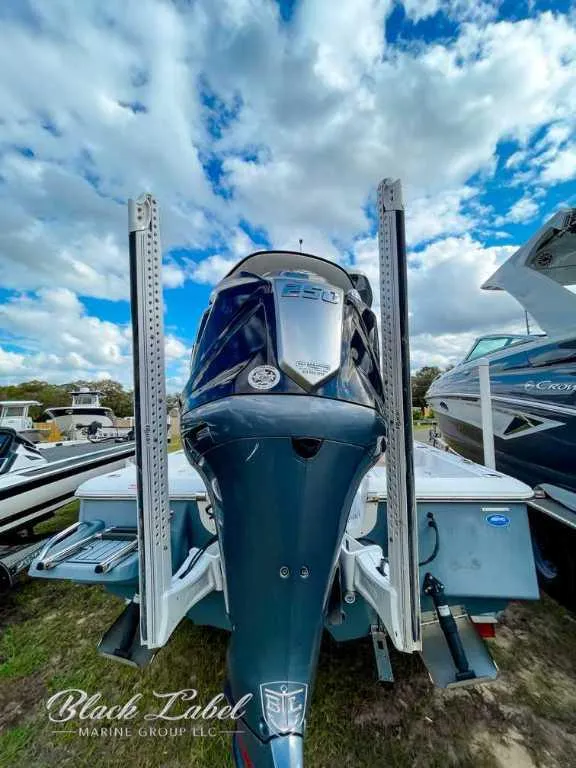 Slide: The Image of 2022 Tidewater 2210 Carolina Bay boat with powerful outboard motor, under a vibrant sky. - 2