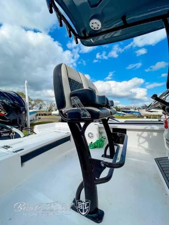 Slide: The Image of 2022 Tidewater 2210 Carolina Bay boat interior with seating and clear sky background. - 4