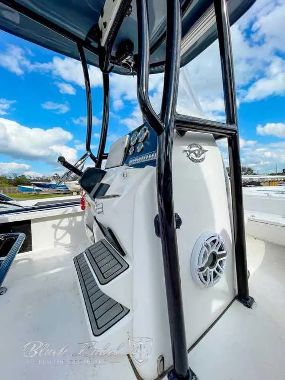 Slide: The Image of 2022 Tidewater 2210 Carolina Bay boat console with black frame and speaker, under blue sky. - 5