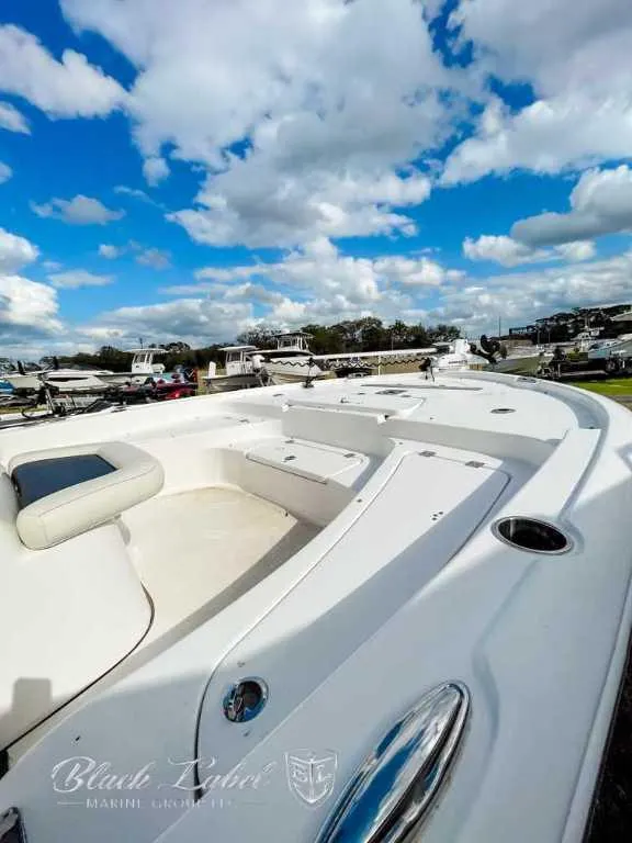 Slide: The Image of 2022 Tidewater 2210 Carolina Bay boat under a vibrant blue sky with clouds. - 6