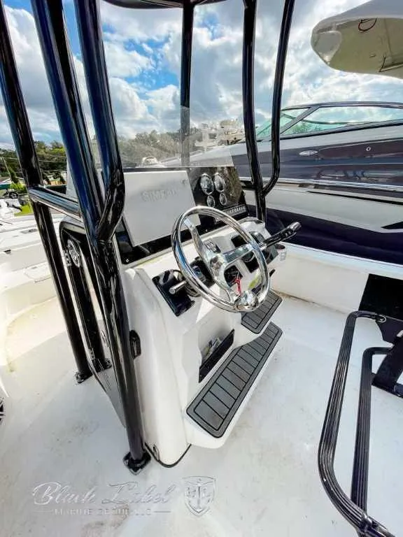 Slide: The Image of 2022 Tidewater 2210 Carolina Bay boat console with steering wheel and controls. - 7