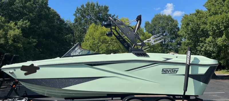 Slide: The Image of 2023 HEYDAY WAKE BOATS H20 in a parking lot with trees in the background. - 10