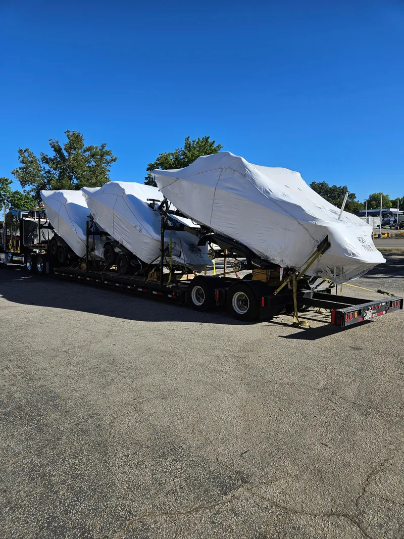 Slide: The Image of 2023 HEYDAY WAKE BOATS H20 models covered on a trailer under clear blue sky. - 3
