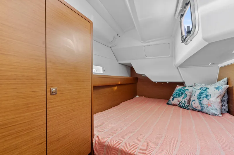 Slide: The Image of Cozy cabin interior of 2020 Jeanneau Sun Odyssey 389 with wooden finish and patterned bedding. - 11