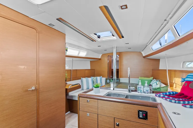 Slide: The Image of Interior of 2020 Jeanneau Sun Odyssey 389 sailboat, featuring modern kitchen and seating area. - 13