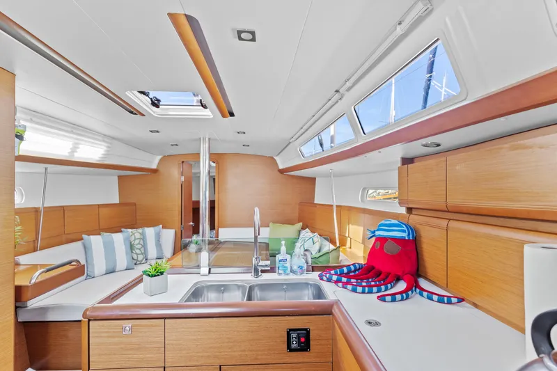 Slide: The Image of Interior of 2020 Jeanneau Sun Odyssey 389 sailboat with modern kitchen and seating area. - 16