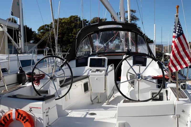Slide: The Image of 2020 Jeanneau Sun Odyssey 389 sailboat cockpit with dual steering wheels and navigation equipment. - 2