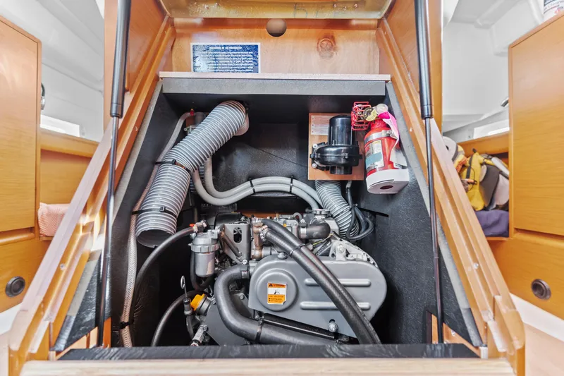 Slide: The Image of Engine compartment of 2020 Jeanneau Sun Odyssey 389 sailboat, featuring mechanical components and fire extinguisher. - 28