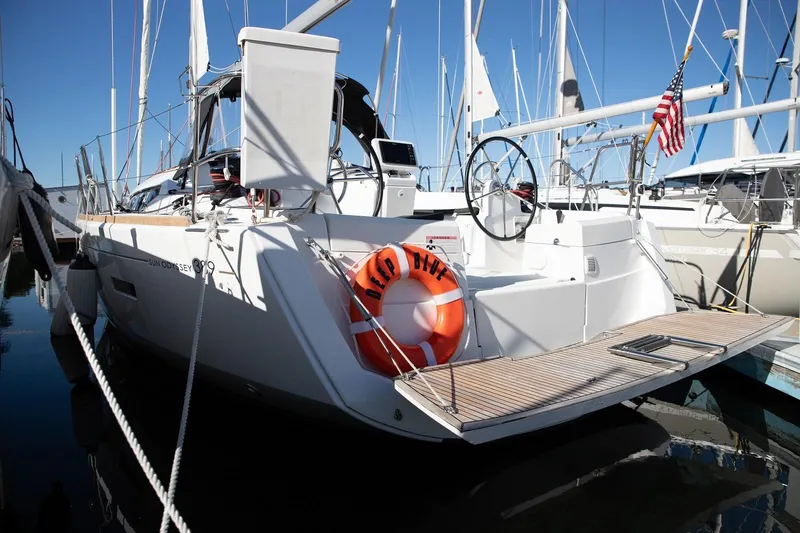 Slide: The Image of 2020 Jeanneau Sun Odyssey 389 yacht docked, featuring sleek design and American flag. - 4