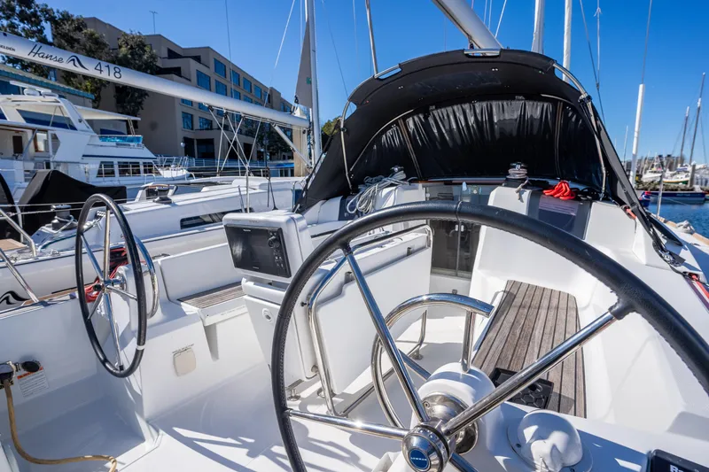 Slide: The Image of 2020 Jeanneau Sun Odyssey 389 sailboat cockpit with dual steering wheels in marina. - 8