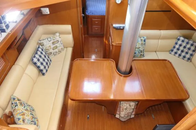 Slide: The Image of Interior of 2002 Tayana 460 Vancouver Pilothouse with wooden table and beige seating. - 16