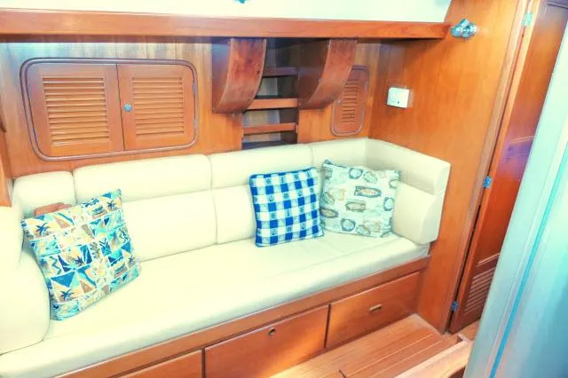 Slide: The Image of Interior of 2002 Tayana 460 Vancouver Pilothouse with cushioned seating and decorative pillows. - 19