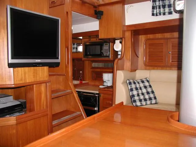 Slide: The Image of Interior of 2002 Tayana 460 Vancouver Pilothouse with wood finish, TV, and seating area. - 25