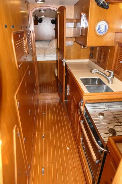 Slide: The Image of 2002 Tayana 460 Vancouver Pilothouse galley with wood finish, stove, and sink. - 30