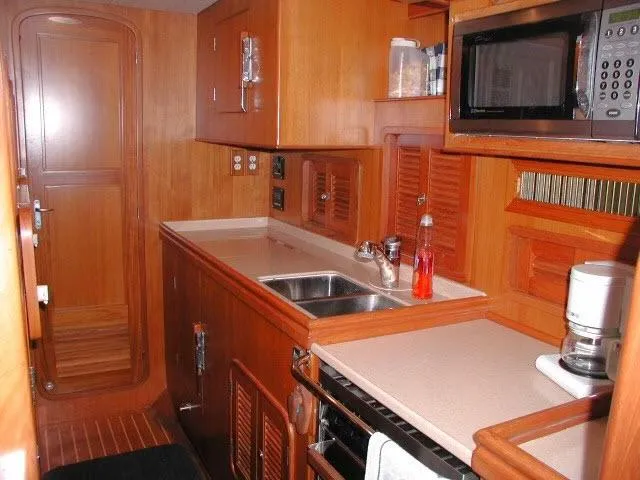 Slide: The Image of Interior of 2002 Tayana 460 Vancouver Pilothouse yacht kitchen with wood cabinetry and appliances. - 32