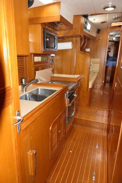 Slide: The Image of Interior of 2002 Tayana 460 Vancouver Pilothouse with wooden cabinetry and modern kitchen amenities. - 33