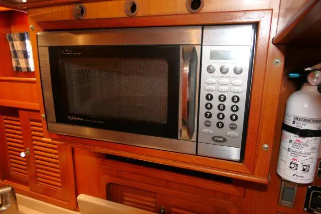 Slide: The Image of Microwave in 2002 Tayana 460 Vancouver Pilothouse kitchen with wooden cabinetry and fire extinguisher. - 37