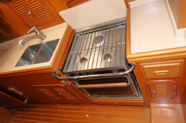Slide: The Image of Tayana 460 Vancouver Pilothouse 2002 kitchen with stove, sink, and wooden cabinetry. - 38