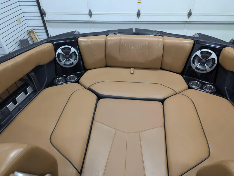 Slide: The Image of 2021 Malibu Wakesetter 24 MXZ interior with tan leather seating and built-in speakers. - 12