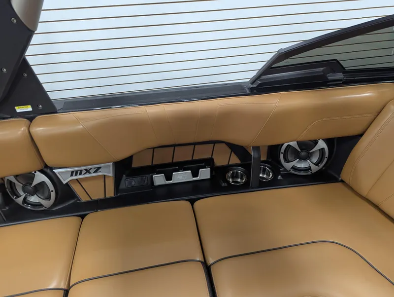 Slide: The Image of 2021 Malibu Wakesetter 24 MXZ interior with tan leather seats and built-in speakers. - 14