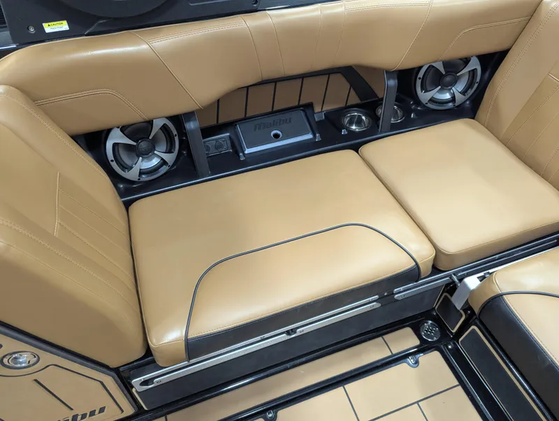 Slide: The Image of 2021 Malibu Wakesetter 24 MXZ interior with tan leather seating and built-in speakers. - 16