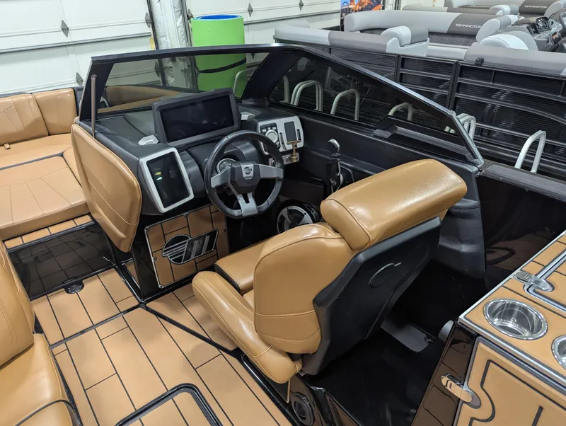 Slide: The Image of 2021 Malibu Wakesetter 24 MXZ boat interior with tan leather seats and modern dashboard. - 18