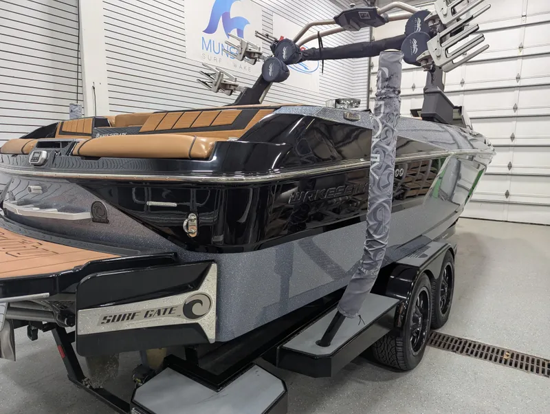Slide: The Image of 2021 Malibu Wakesetter 24 MXZ boat in showroom, featuring sleek design and Surf Gate technology. - 2