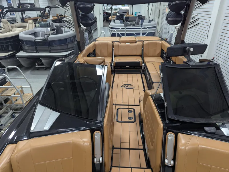 Slide: The Image of 2021 Malibu Wakesetter 24 MXZ interior with tan seating and sleek black accents. - 22