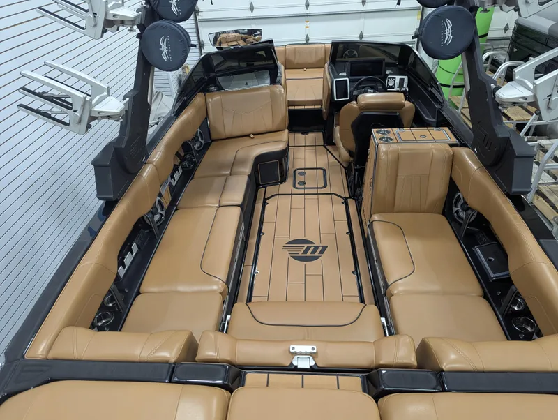 Slide: The Image of 2021 Malibu Wakesetter 24 MXZ interior with tan leather seating and modern dashboard. - 24