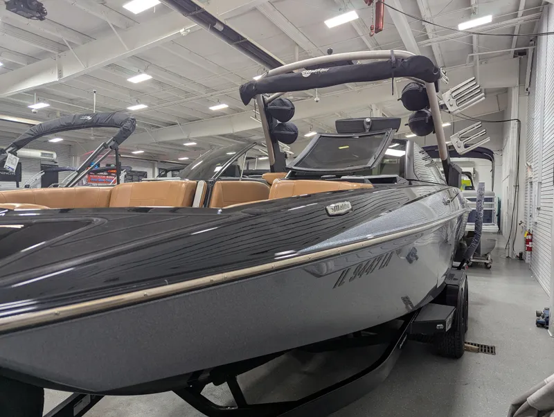 Slide: The Image of 2021 Malibu Wakesetter 24 MXZ boat in showroom, sleek design, luxury seating. - 6