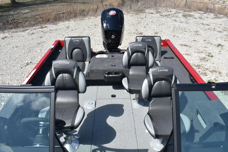 Slide: The Image of 2025 Lund 1775 Impact XS Sport boat interior with six gray seats and a motor. - 15