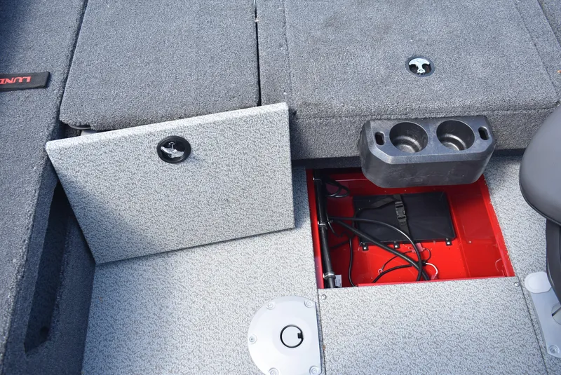 Slide: The Image of 2025 Lund 1775 Impact XS Sport boat interior with storage compartments and cup holders. - 19