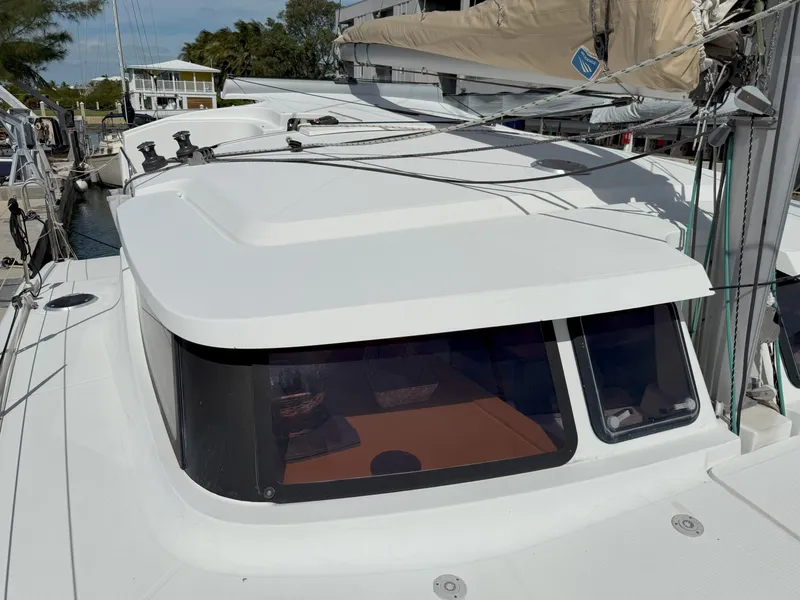 Slide: The Image of 2014 Fountaine Pajot Mahe 36 Evolution catamaran, docked, showcasing sleek design and spacious deck. - 13