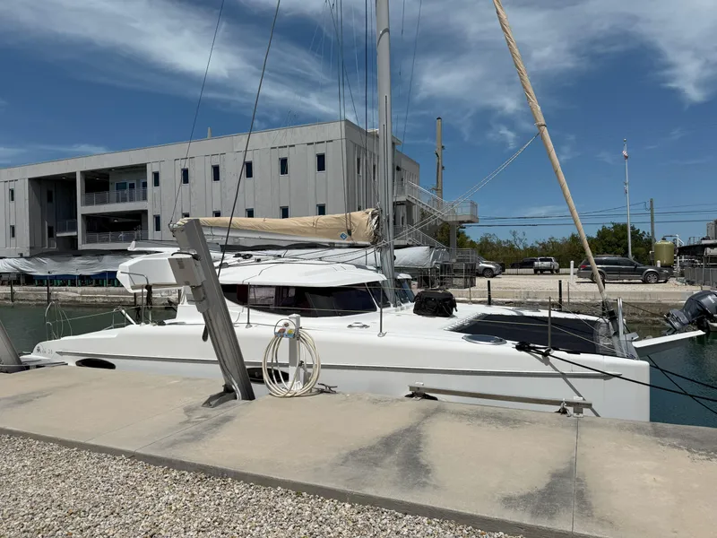 Slide: The Image of 2014 Fountaine Pajot Mahe 36 Evolution catamaran docked at marina, clear sky background. - 2