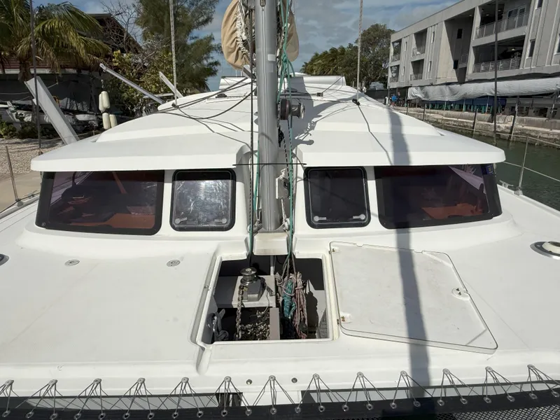 Slide: The Image of 2014 Fountaine Pajot Mahe 36 Evolution catamaran docked, front view with visible windows and mast. - 48