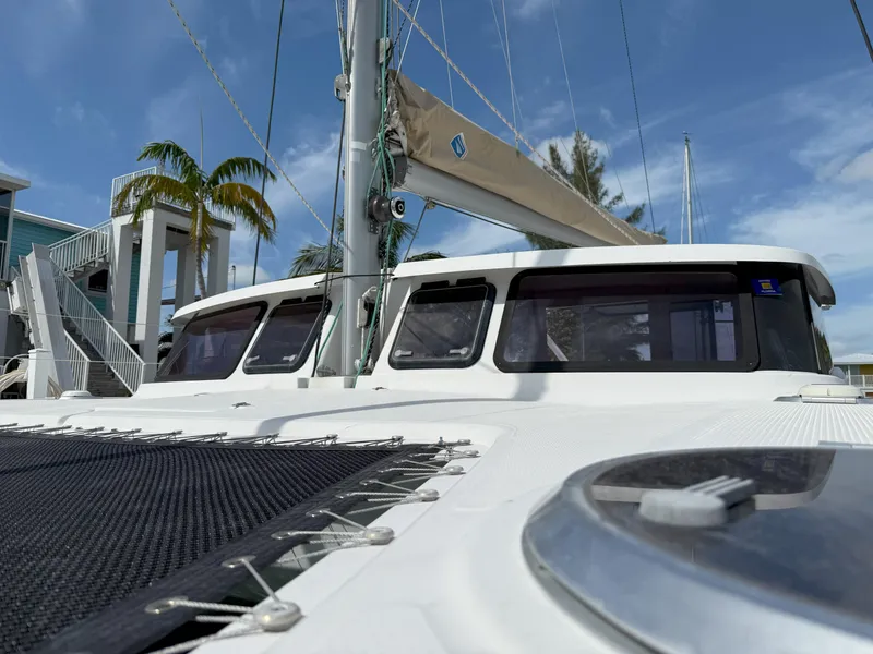 Slide: The Image of 2014 Fountaine Pajot Mahe 36 Evolution catamaran, docked with palm trees in the background. - 8