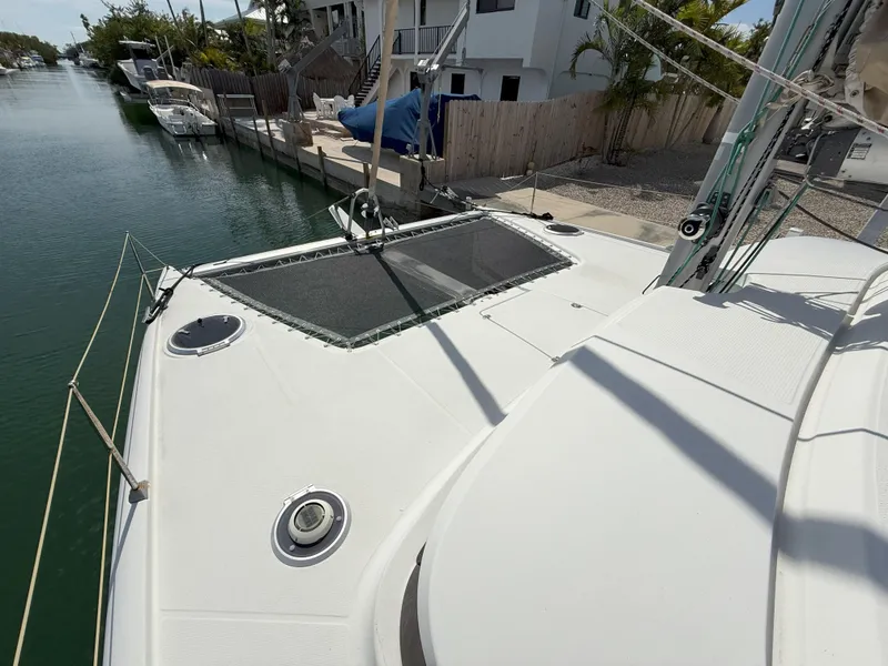 Slide: The Image of 2014 Fountaine Pajot Mahe 36 Evolution catamaran docked by waterfront homes. - 15