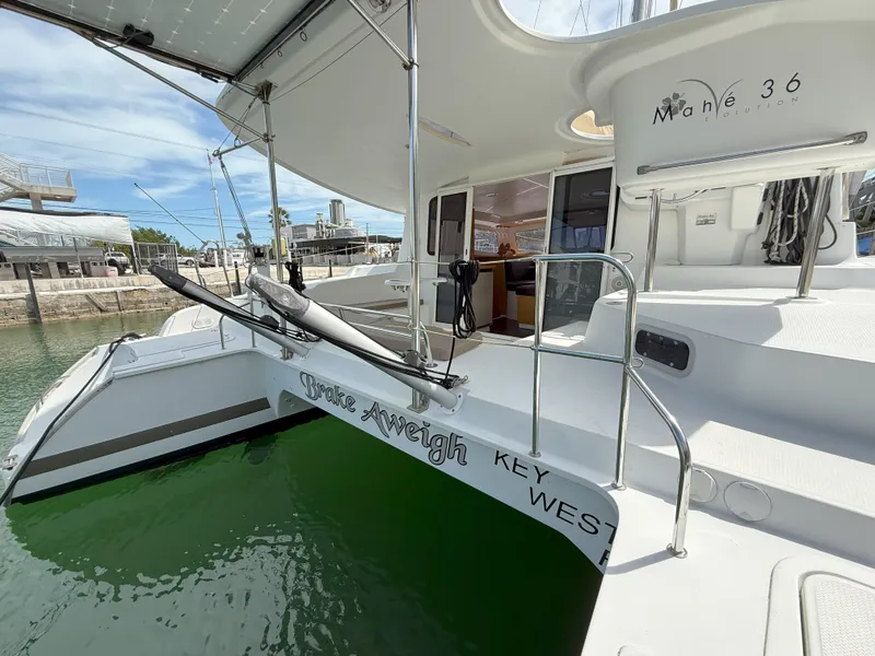 Slide: The Image of 2014 Fountaine Pajot Mahe 36 Evolution catamaran docked, featuring spacious deck and modern design. - 16