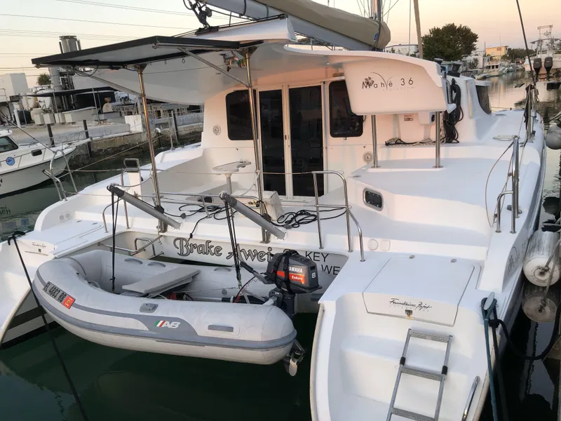 Slide: The Image of 2014 Fountaine Pajot Mahe 36 Evolution catamaran docked with dinghy attached. - 19