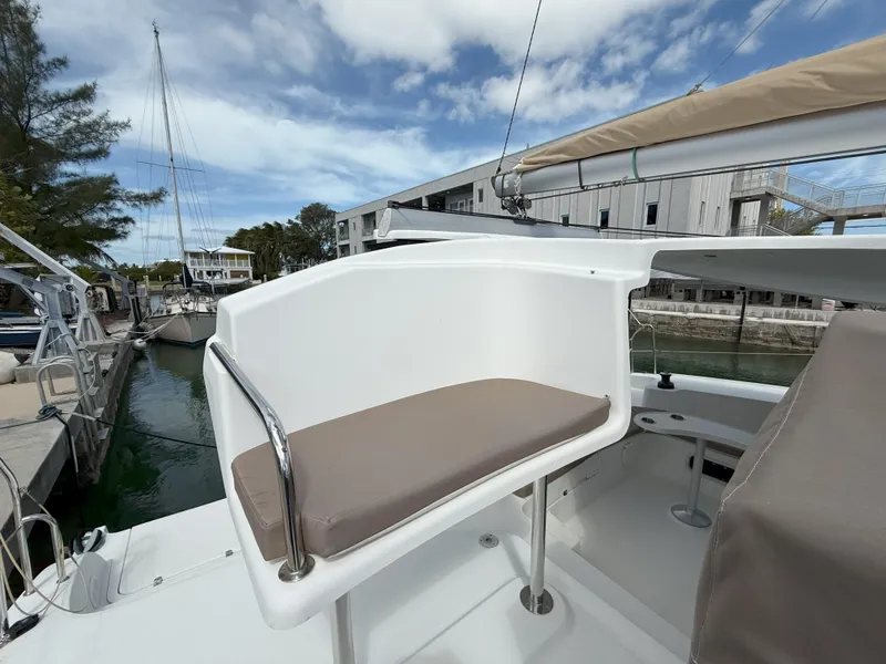 Slide: The Image of 2014 Fountaine Pajot Mahe 36 Evolution yacht helm station with cushioned seat, docked at marina. - 35
