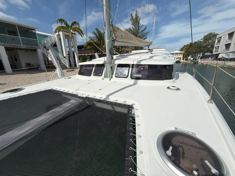 Slide: The Image of 2014 Fountaine Pajot Mahe 36 Evolution catamaran docked, showcasing deck and netting. - 9