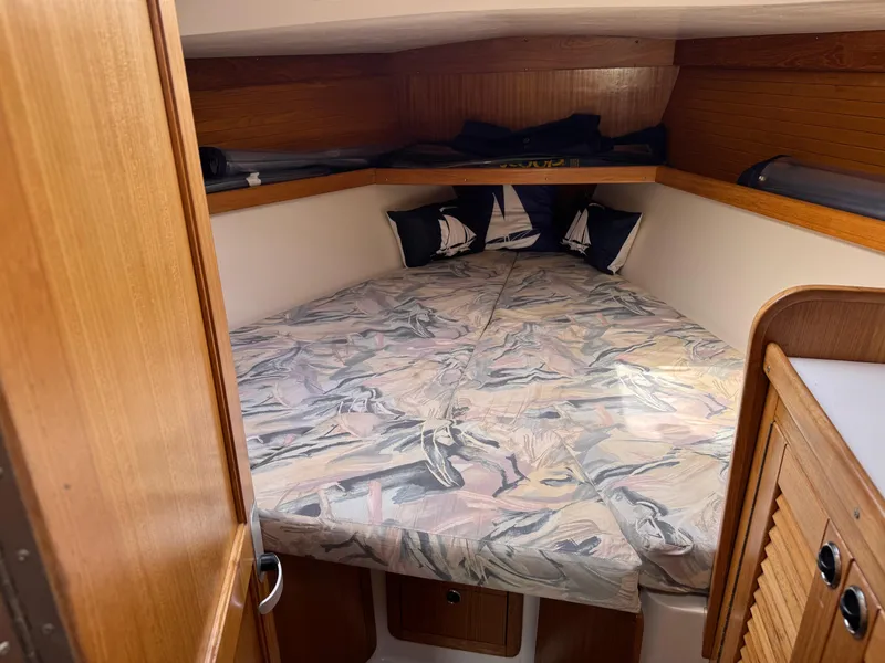Slide: The Image of 1999 Catalina 36 Mk II cabin interior with cozy bed and wooden accents. - 24