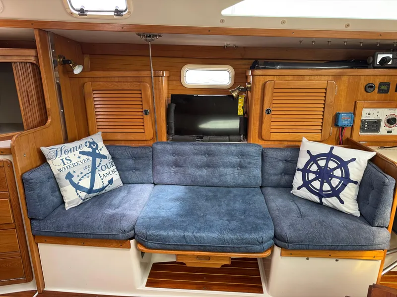 Slide: The Image of Interior of 1999 Catalina 36 Mk II sailboat with blue cushioned seating and nautical-themed pillows. - 27