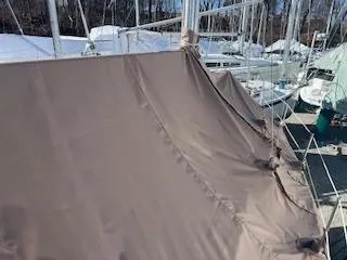Slide: The Image of Brown tarp covering a 1999 Catalina 36 Mk II sailboat, docked with other boats. - 36
