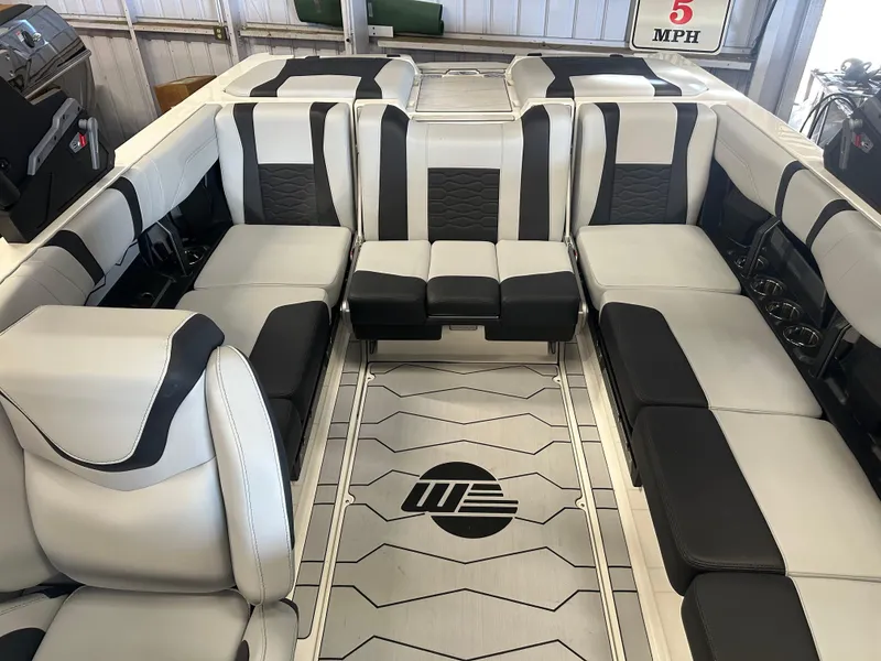 Slide: The Image of 2025 Malibu 23 MXZ boat interior with sleek black and white seating design. - 10