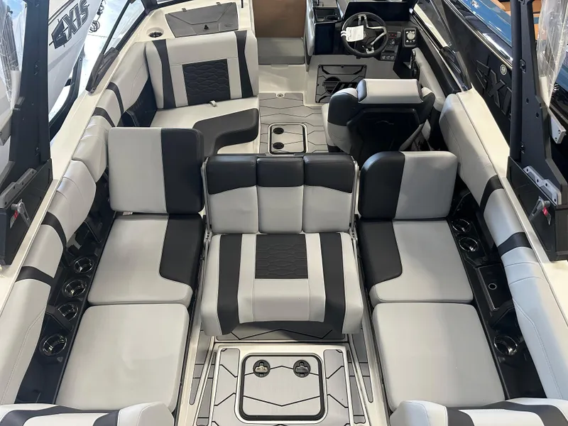 Slide: The Image of 2025 Malibu 23 MXZ boat interior with sleek black and white seating design. - 12