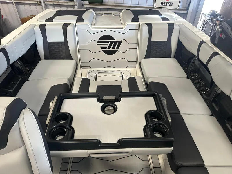 Slide: The Image of 2025 Malibu 23 MXZ boat interior with sleek seating and cup holders. - 13