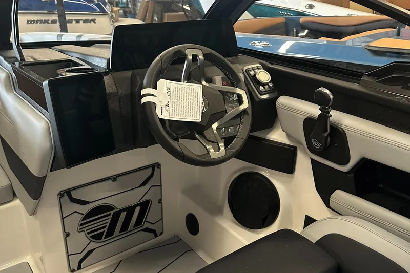 Slide: The Image of 2025 Malibu 23 MXZ boat interior with modern steering and control panel. - 14