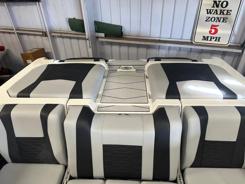 Slide: The Image of 2025 Malibu 23 MXZ boat interior with sleek black and white seating design. - 6